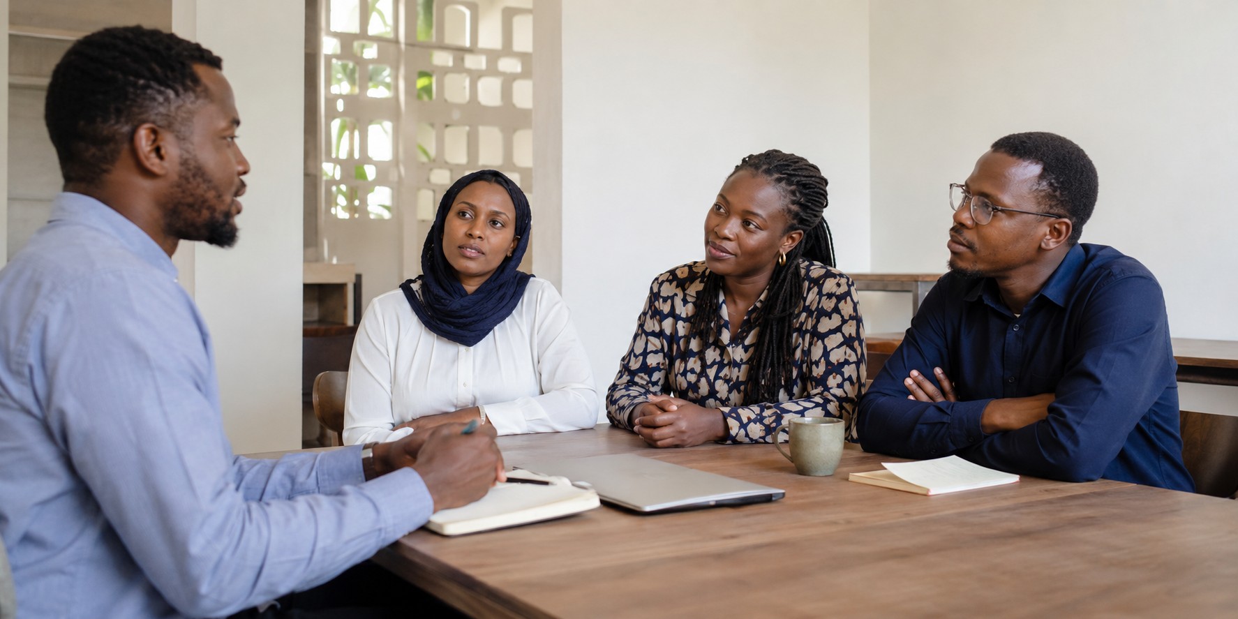 ETiCA specialist in discussion with colleagues around a meeting table
